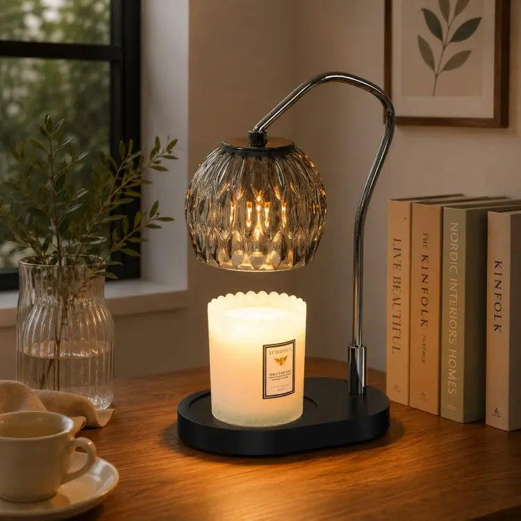 Black candle warmer lamp with timer and dimmer warming a scented jar candle on a wooden table in a modern living room