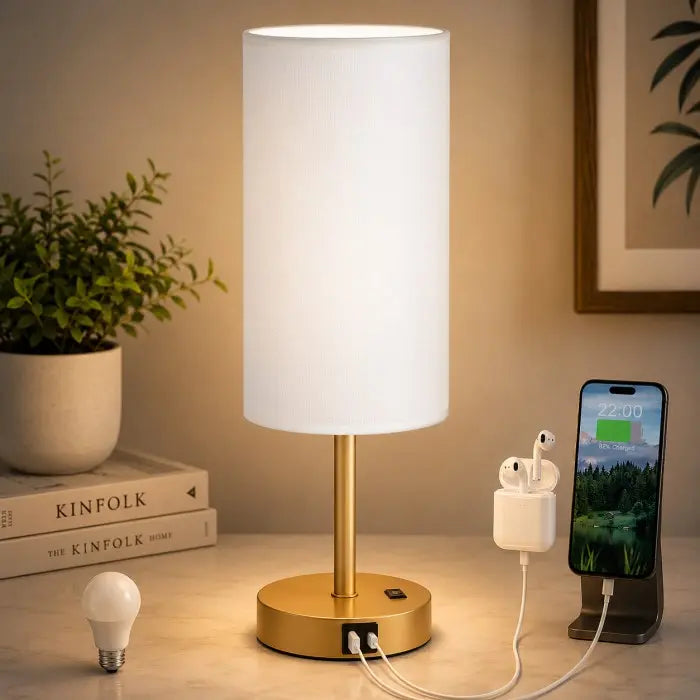 Modern bedside table lamp with USB charging port, 3-way dimmable touch control, linen fabric shade, and wooden base on a bedroom nightstand with warm ambient lighting.